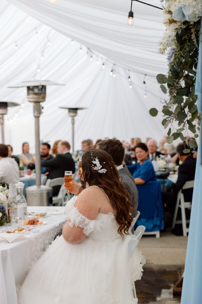 Guests keep warm during a chilly outdoor wedding ceremony in Southern California by sitting near space heaters.