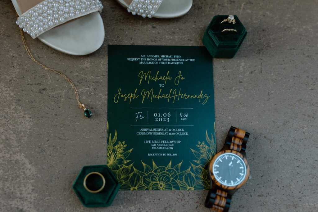 A dark and moody wedding day flat lay photographed by Laura Burns Photography